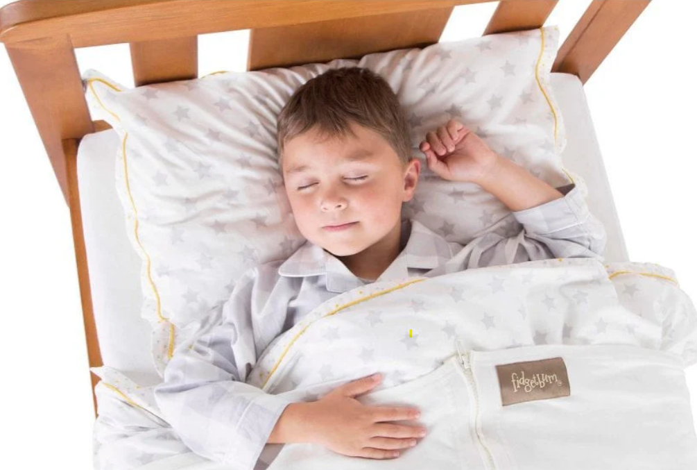 Child sleeping on bed with Fidgetbum product